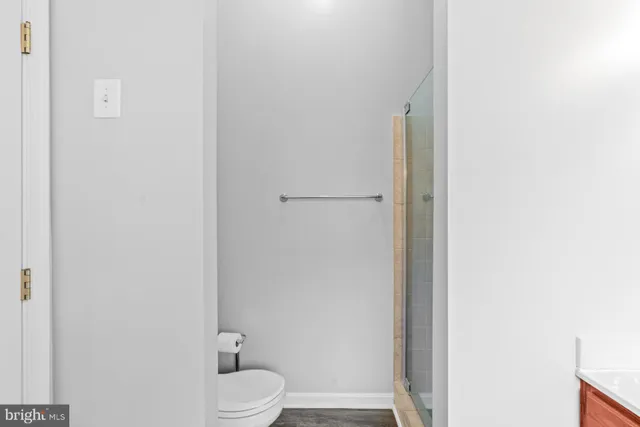 a white toilet sitting next to a white wall