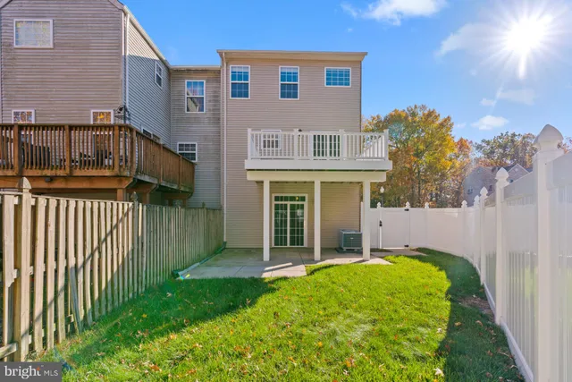 a view of a house with a small yard and wooden floor and fence