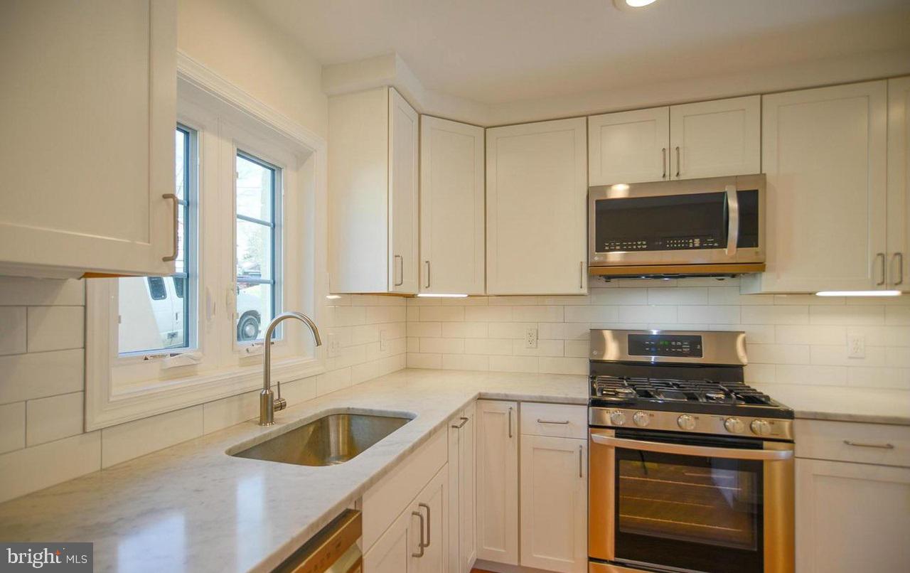 2503 Holman Avenue Silver Spring, MD 20910 - Photo 4 of 15 a kitchen with granite countertop a stove a sink and a microwave