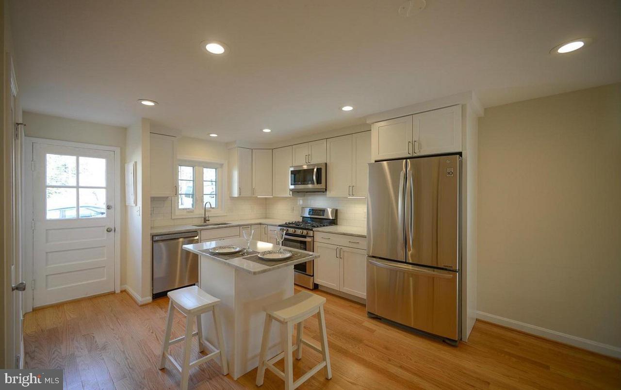 2503 Holman Avenue Silver Spring, MD 20910 - Photo 7 of 15 a kitchen with stainless steel appliances granite countertop a refrigerator and a stove top oven