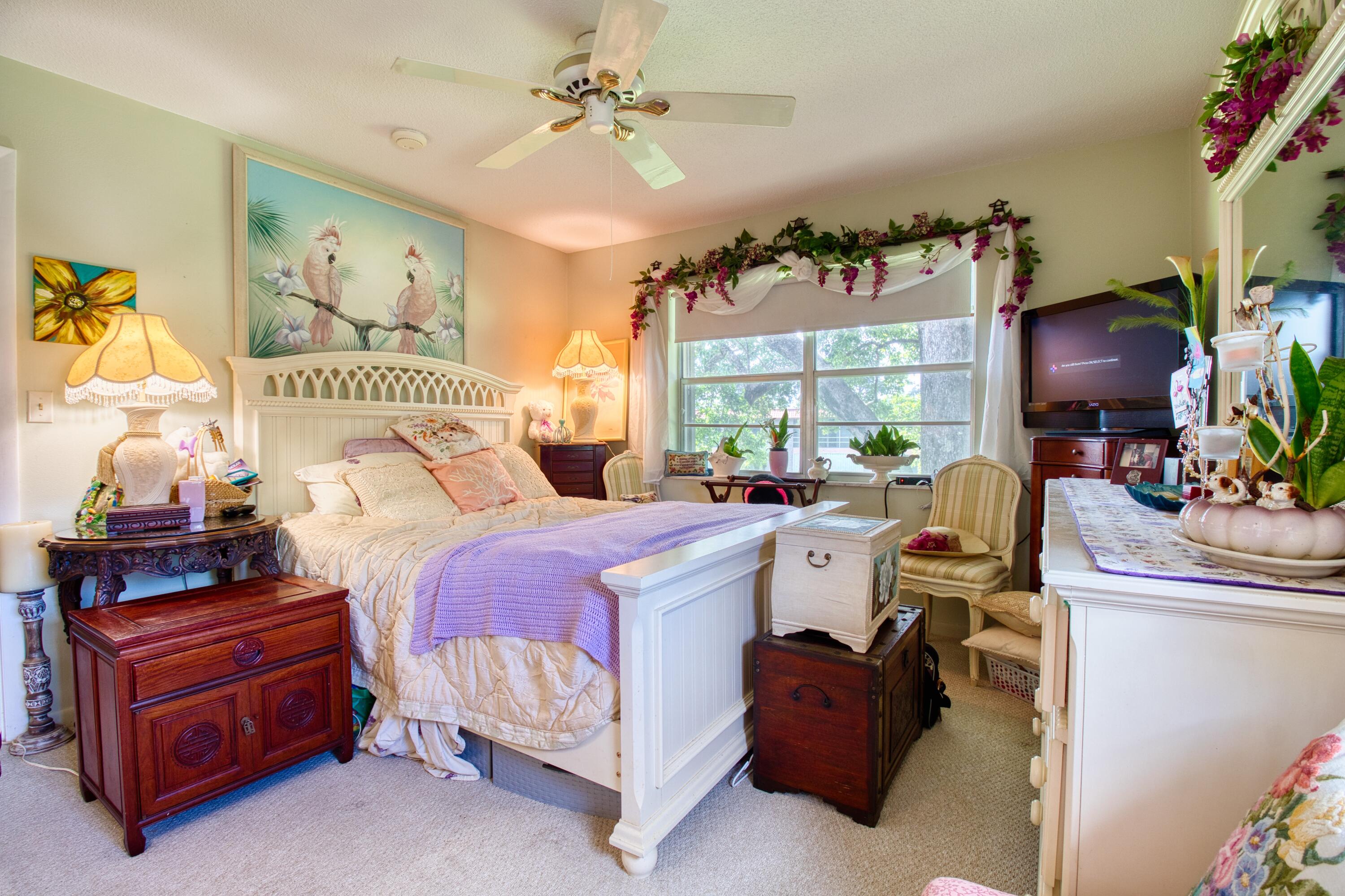 1911 Southwest Palm City Road, Unit J Stuart, FL 34994 - Photo 6 of 21 a bedroom with a bed and a chandelier