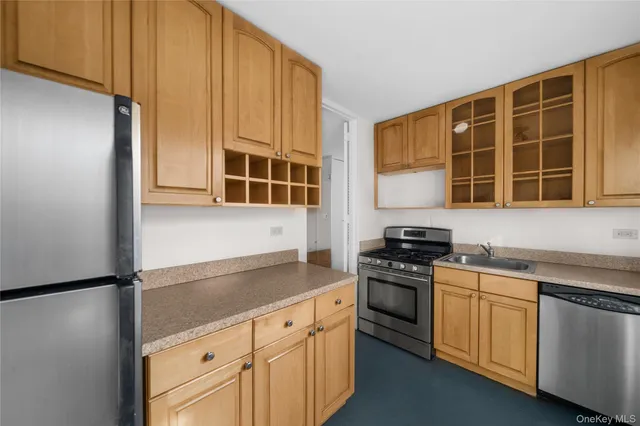 a kitchen with stainless steel appliances granite countertop a stove a sink and a refrigerator