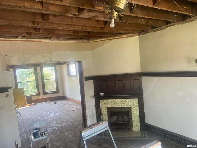 a view of an empty room with a fireplace and a window