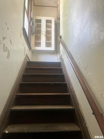 a view of staircase with lots of frames on wall