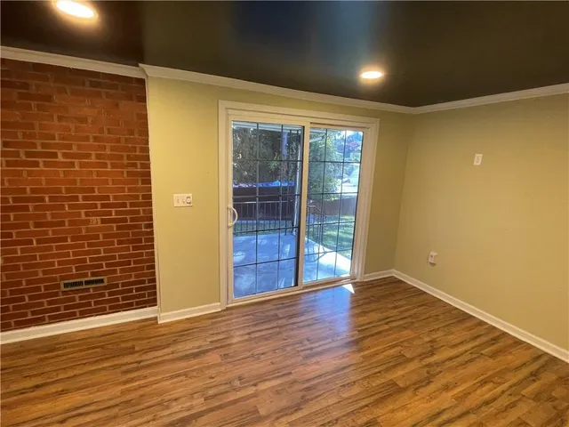 a view of a room with wooden floor and a window