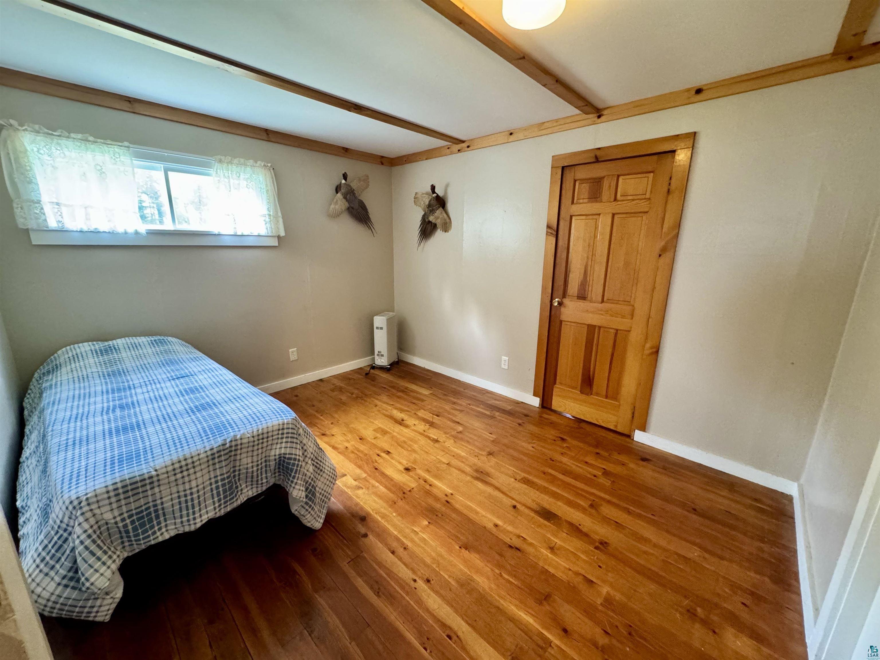 9724 State Highway 1 Isabella, MN 55607 - Photo 13 of 21 Bedroom featuring hardwood / wood-style flooring, baseboards, and beamed ceiling