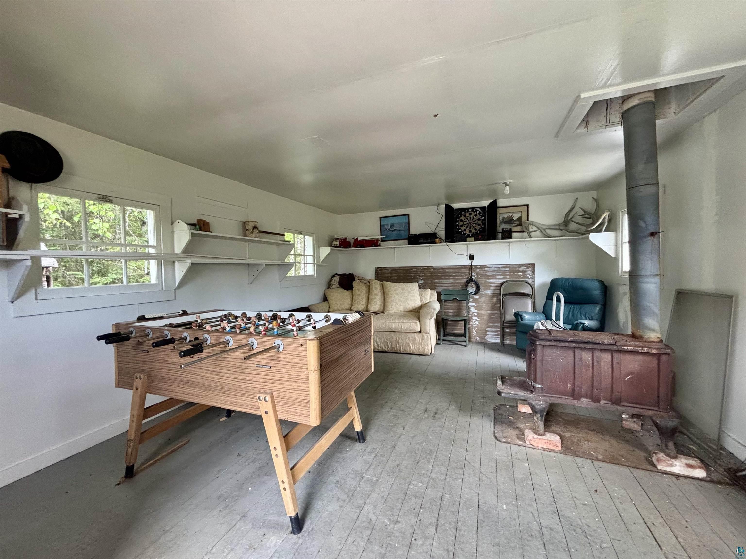 9724 State Highway 1 Isabella, MN 55607 - Photo 19 of 21 Playroom with a wood stove, wood-type flooring, and baseboards