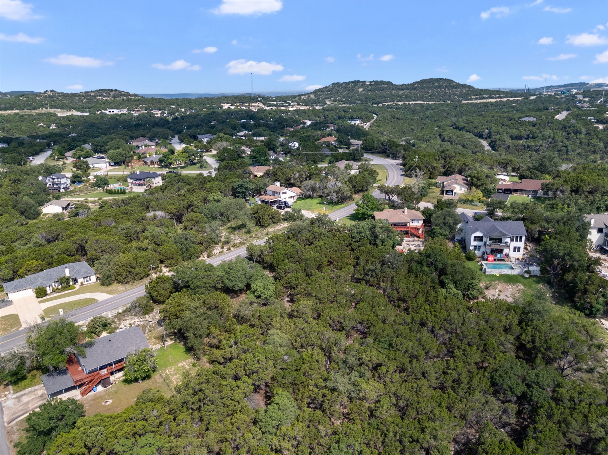 21105 Ridgeview Road Lago Vista, TX 78645 - Photo 10 of 34 An aerial perspective reveals a verdant residential landscape with scattered homes and winding roads under an open sky.