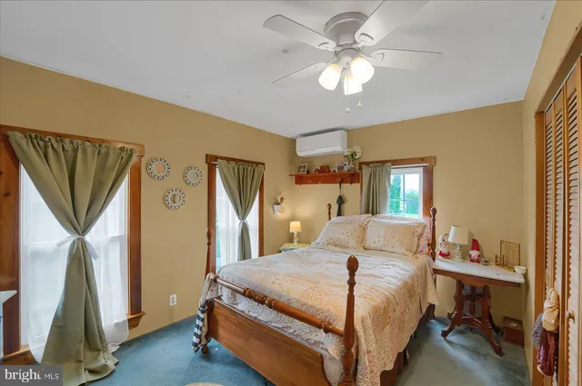 a spacious bedroom with a bed a dresser and a chandelier