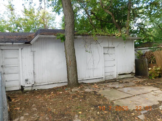 a backyard of a house with large trees and a barn