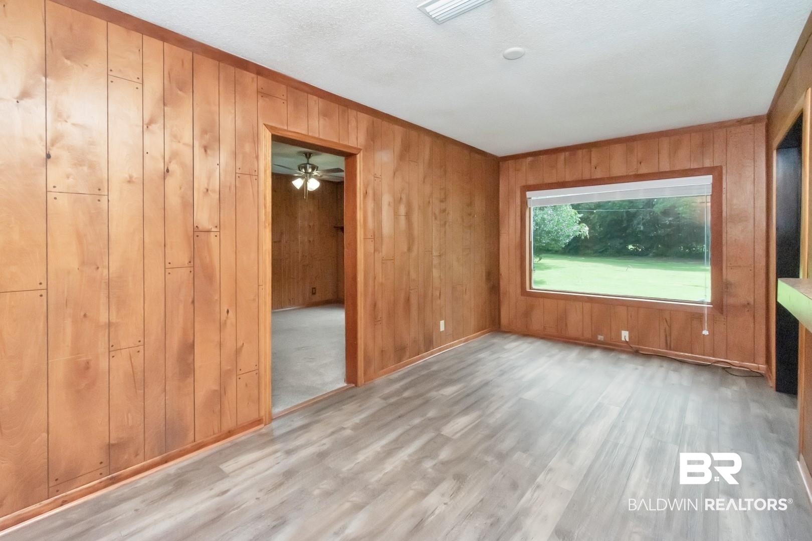 12751 Zanzibar Road Grand Bay, AL 36541 - Photo 7 of 30 Unfurnished room with hardwood / wood-style flooring, wooden walls, and ceiling fan