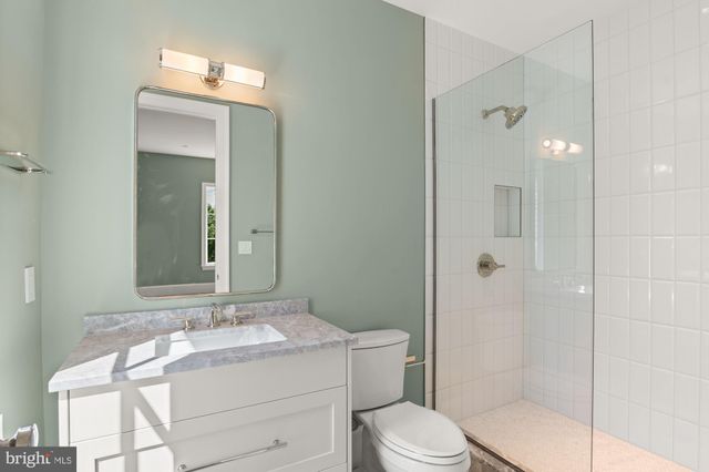 a bathroom with a granite countertop sink toilet a mirror and shower