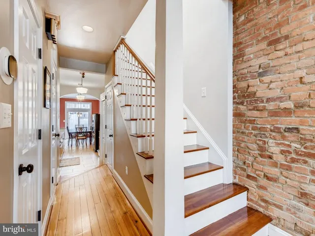 a view of a hallway with wooden floor and staircase