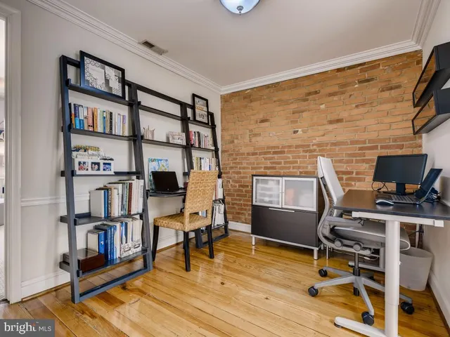a workspace with furniture wooden floor and a book shelf