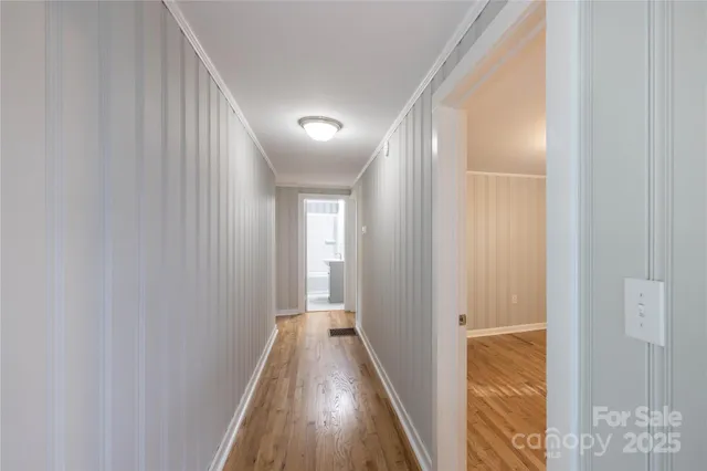a view of a hallway with wooden floor and entryway