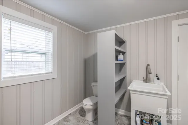 a bathroom with a sink toilet and window
