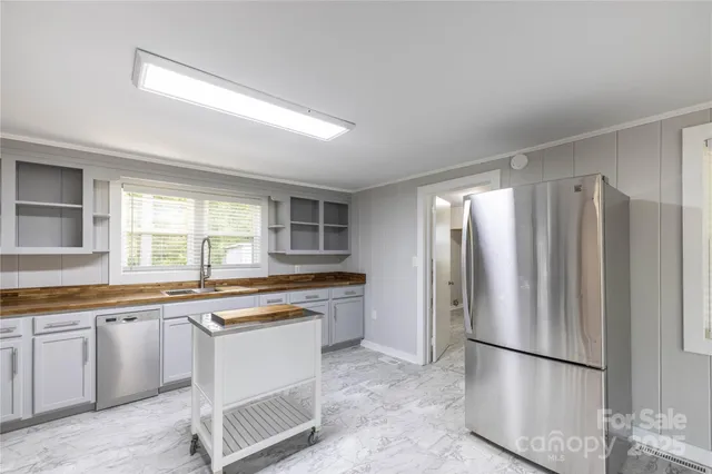 a kitchen with stainless steel appliances granite countertop a refrigerator and a sink