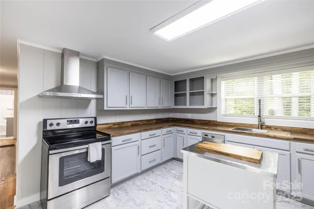 a kitchen with granite countertop a sink stove and cabinets