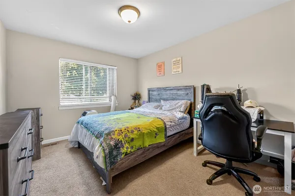 a bedroom with a bed chair and a window