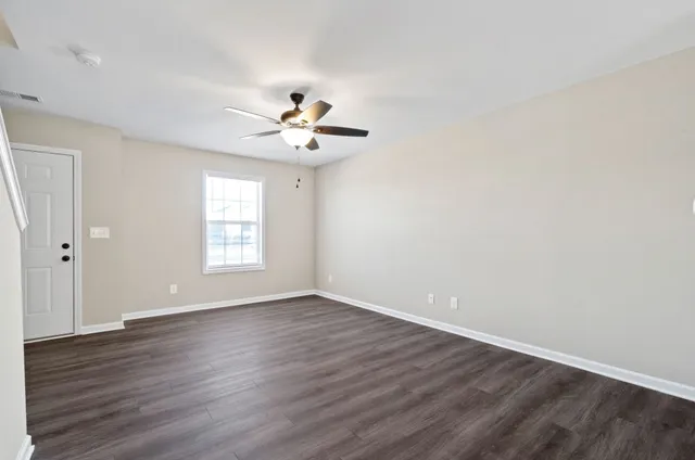 a view of a hallway with wooden floor and a chandelier