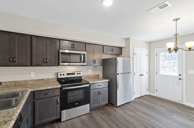 a kitchen with granite countertop a stove microwave and sink
