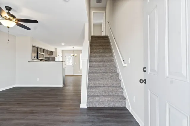 a view of a kitchen with wooden floor and a ceiling fan