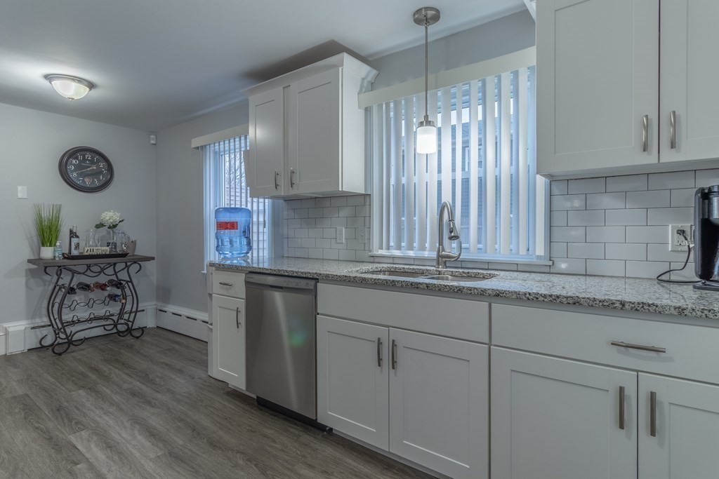 45 Baird Street Fall River, MA 02721 - Photo 9 of 42 a kitchen with stainless steel appliances granite countertop a stove a sink and a refrigerator with wooden cabinets