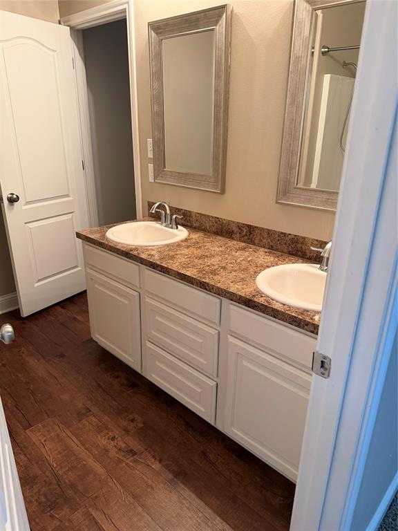 520 Big Red Circle Haughton, LA 71037 - Photo 17 of 25 Double vanity featuring white cabinetry, integrated sinks, a patterned countertop, and framed mirrors