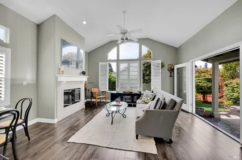 a living room with furniture fireplace and large windows