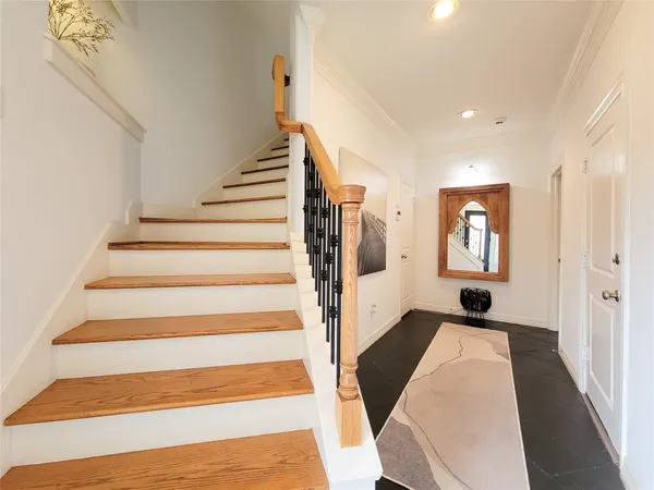 a view of staircase with railing and white walls
