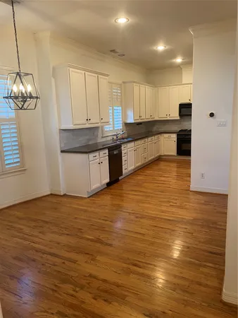 a large kitchen with stainless steel appliances granite countertop a dishwasher a stove and a wooden floors