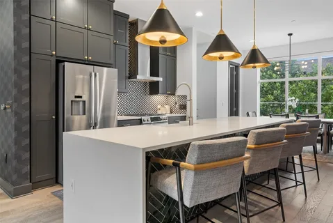 a kitchen with stainless steel appliances granite countertop a sink a stove and a refrigerator