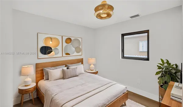 a bedroom with a bed and painting on the wall