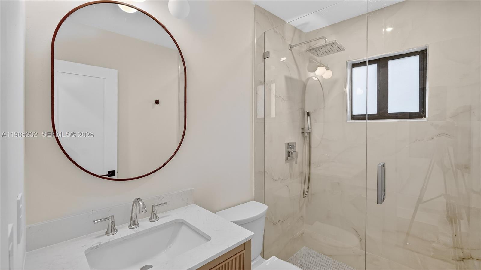 3135 Southwest 7th Street Miami, FL 33135 - Photo 13 of 20 a bathroom with a sink a mirror a vanity and a shower