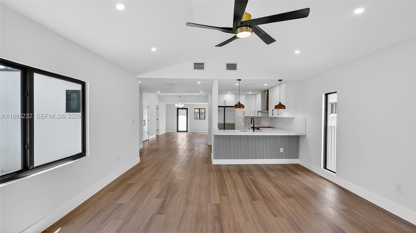 3135 Southwest 7th Street Miami, FL 33135 - Photo 16 of 20 a large kitchen with stainless steel appliances a large counter top a sink a refrigerator and a window