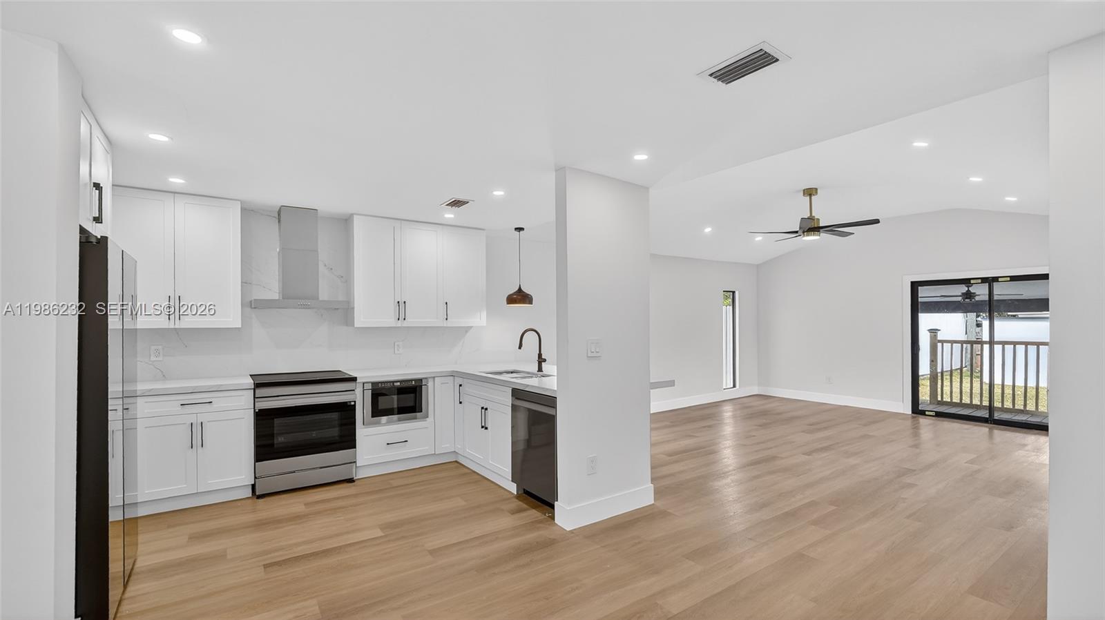 3135 Southwest 7th Street Miami, FL 33135 - Photo 17 of 20 a kitchen with granite countertop a stove and a refrigerator