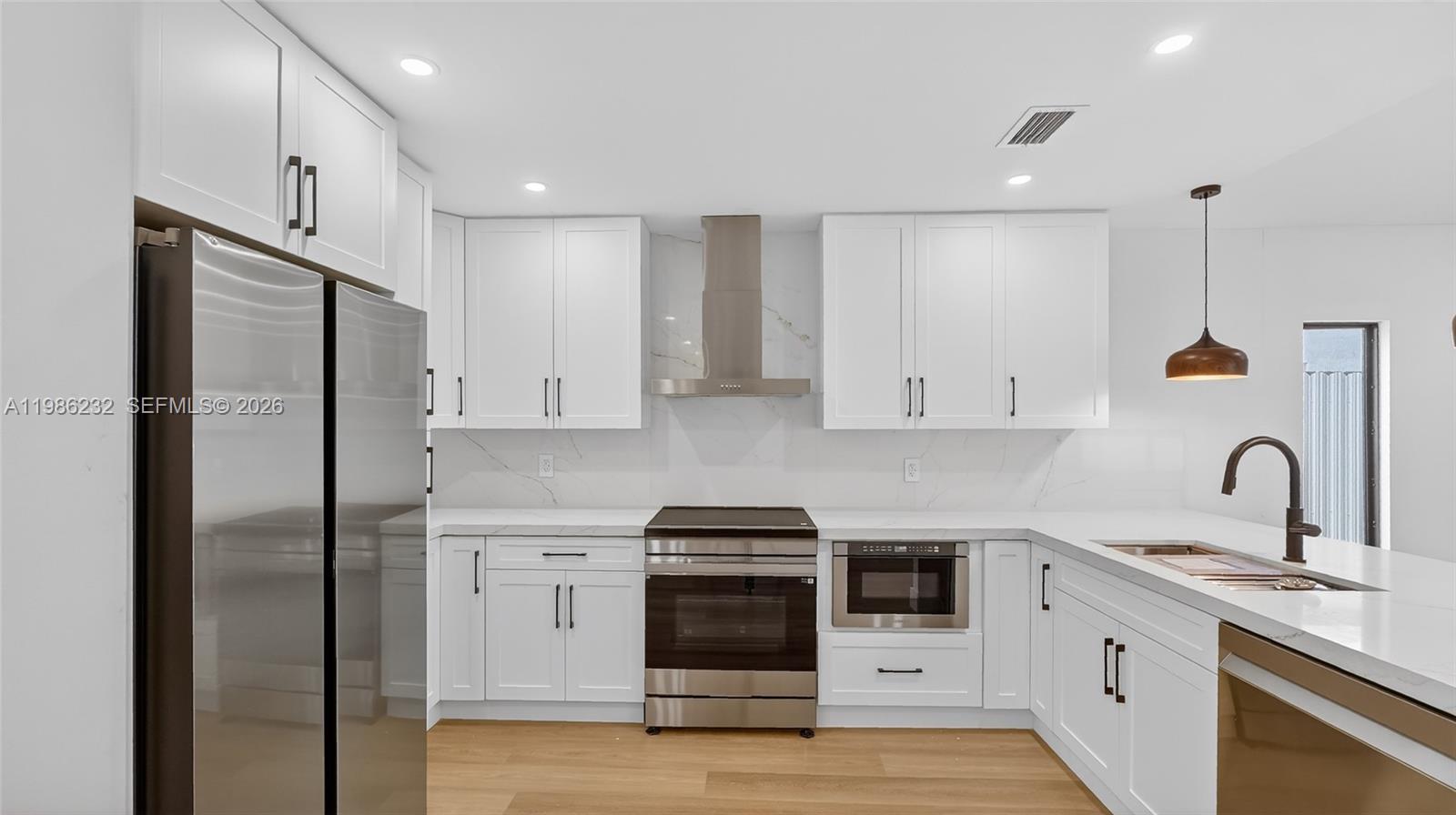 3135 Southwest 7th Street Miami, FL 33135 - Photo 18 of 20 a kitchen with a refrigerator sink and cabinets