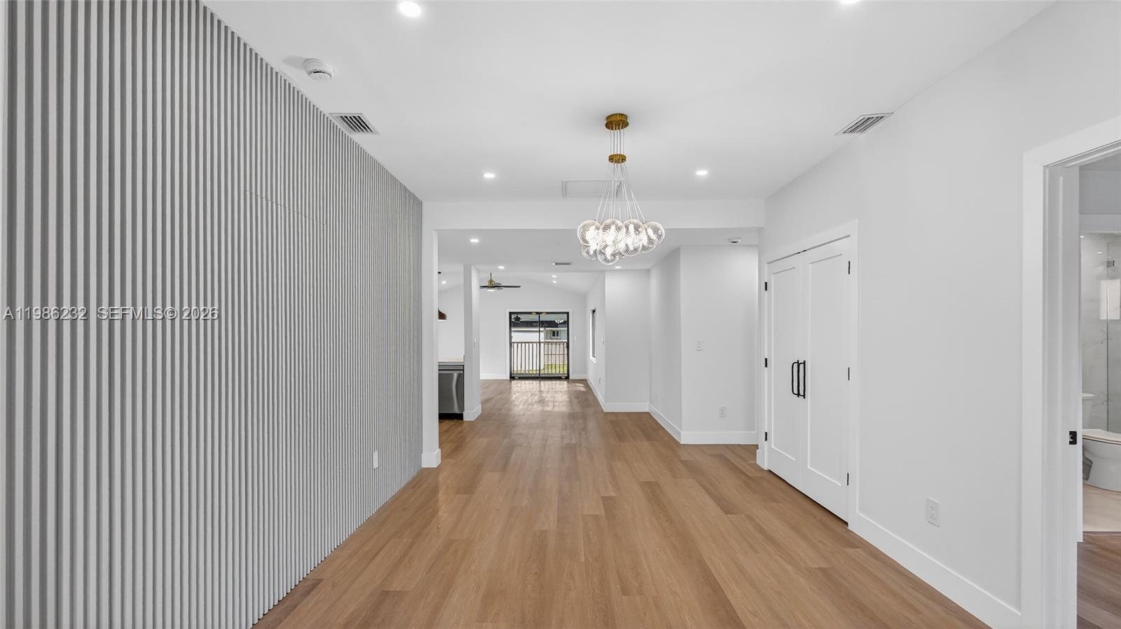 3135 Southwest 7th Street Miami, FL 33135 - Photo 5 of 20 a view of a hallway with wooden floor and a kitchen