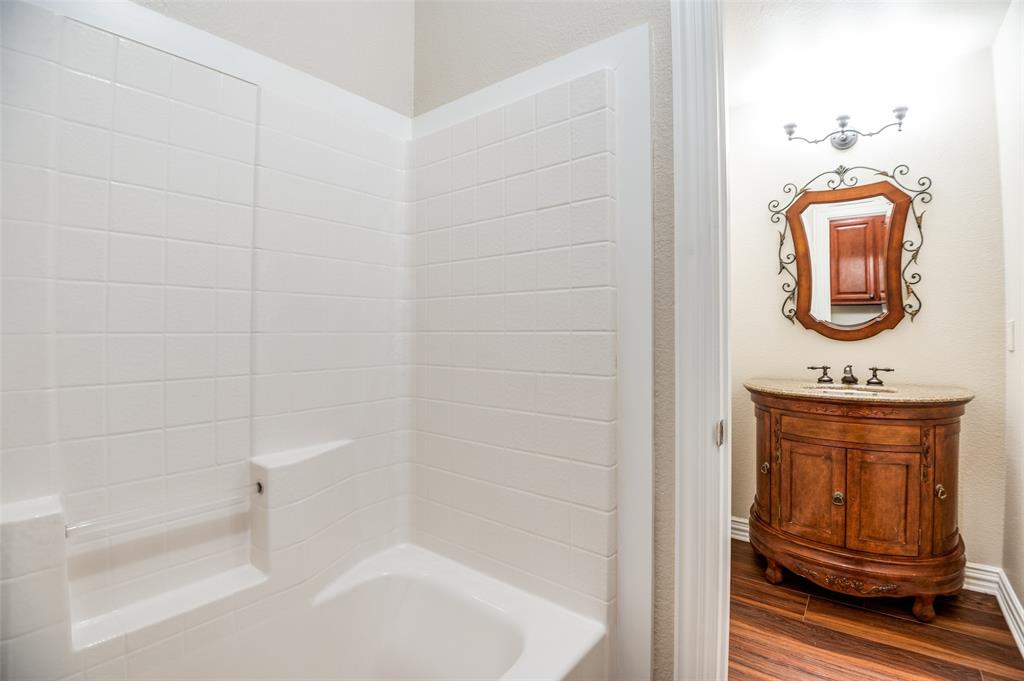 809 Longridge Drive Denton, TX 76205 - Photo 24 of 31 Bathroom featuring a classic white subway tile shower surround and a separate vanity area
