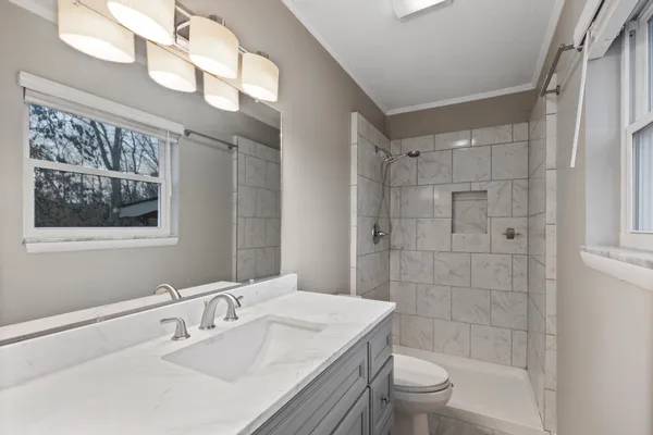 a bathroom with a sink a toilet and shower