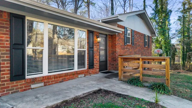 a backyard of a house with barbeque oven and large tree