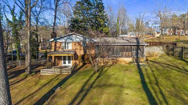 a view of a swimming pool with a patio and a yard