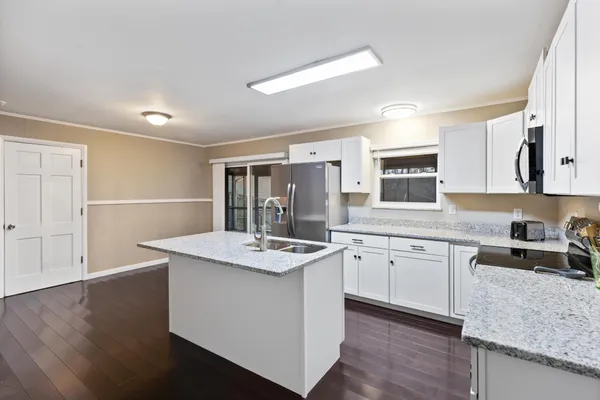 a kitchen with sink cabinets and wooden floor