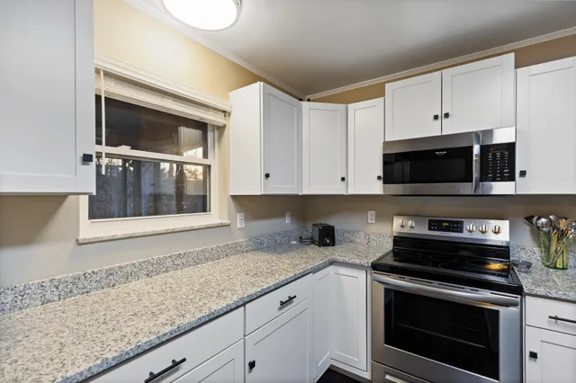 a kitchen with granite countertop a stove and a microwave