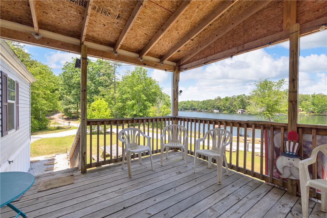 334 Lake Becky Road Mountain Rest, SC 29664 - Photo 4 of 46 A spacious wooden deck provides tranquil views of the serene lake and surrounding greenery.