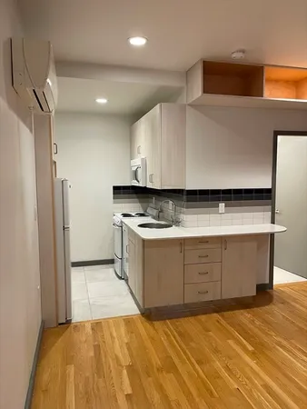 a kitchen with stainless steel appliances a refrigerator sink and white cabinets