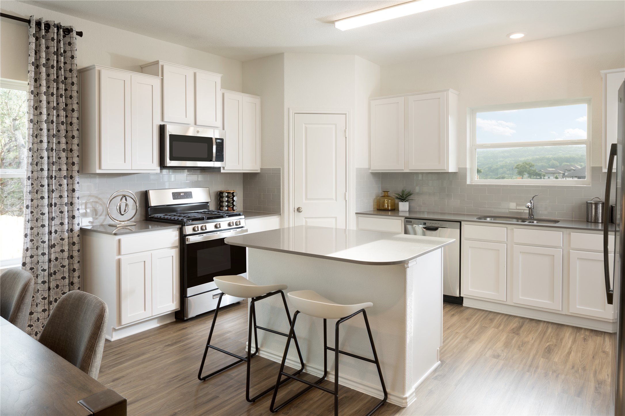 106 Sapling Dew Drive Georgetown, TX 78628 - Photo 10 of 22 a kitchen with stainless steel appliances white cabinets a sink a stove a window and dining table