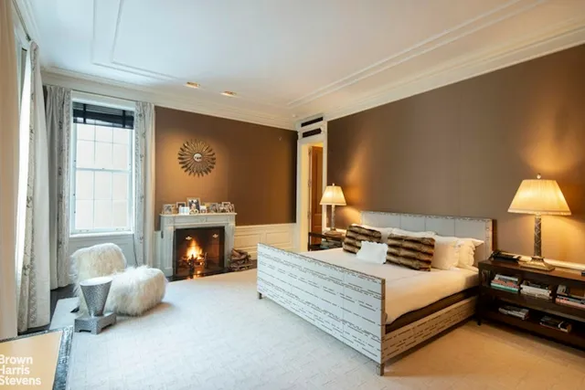 a spacious bedroom with a bed and a fireplace