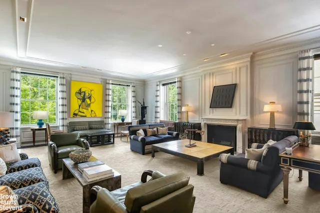 a living room with furniture fireplace and a large window