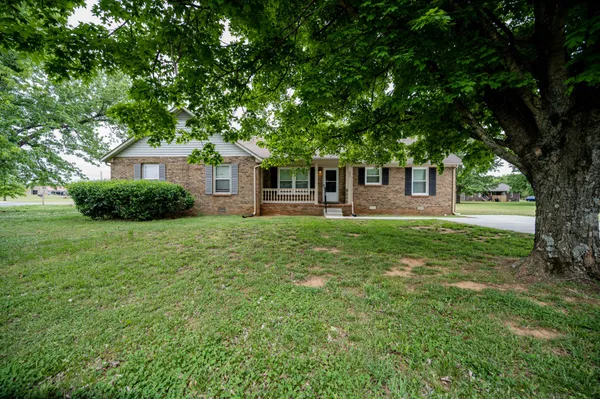 a front view of a house with yard and green space